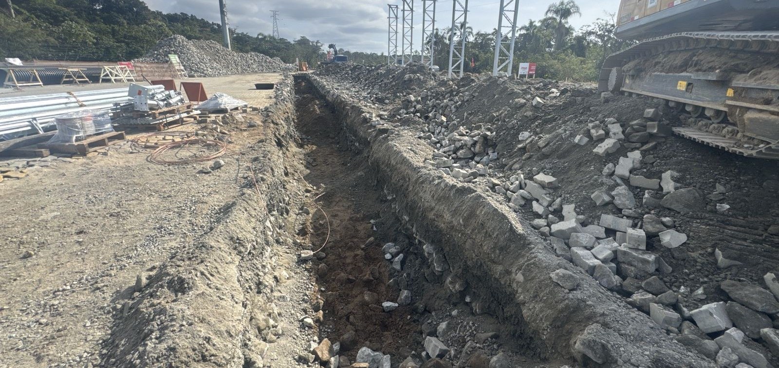 Vala de infraestrutura aberta ao lado das torres de iluminação - MSE Engenharia