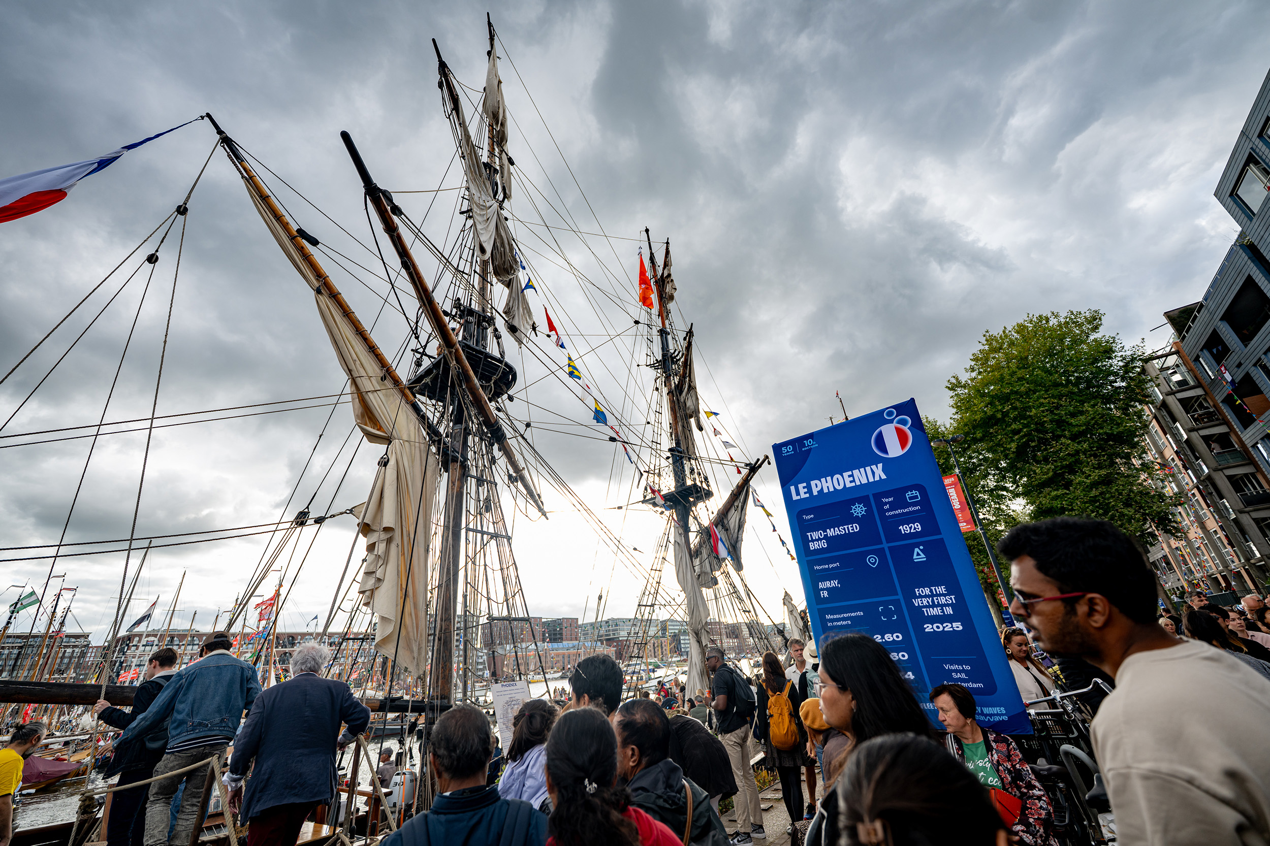 Tall ship Le Phoenix met een lollypop-infobord in de huisstijl van SAIL 2025, en veel bezoekers.