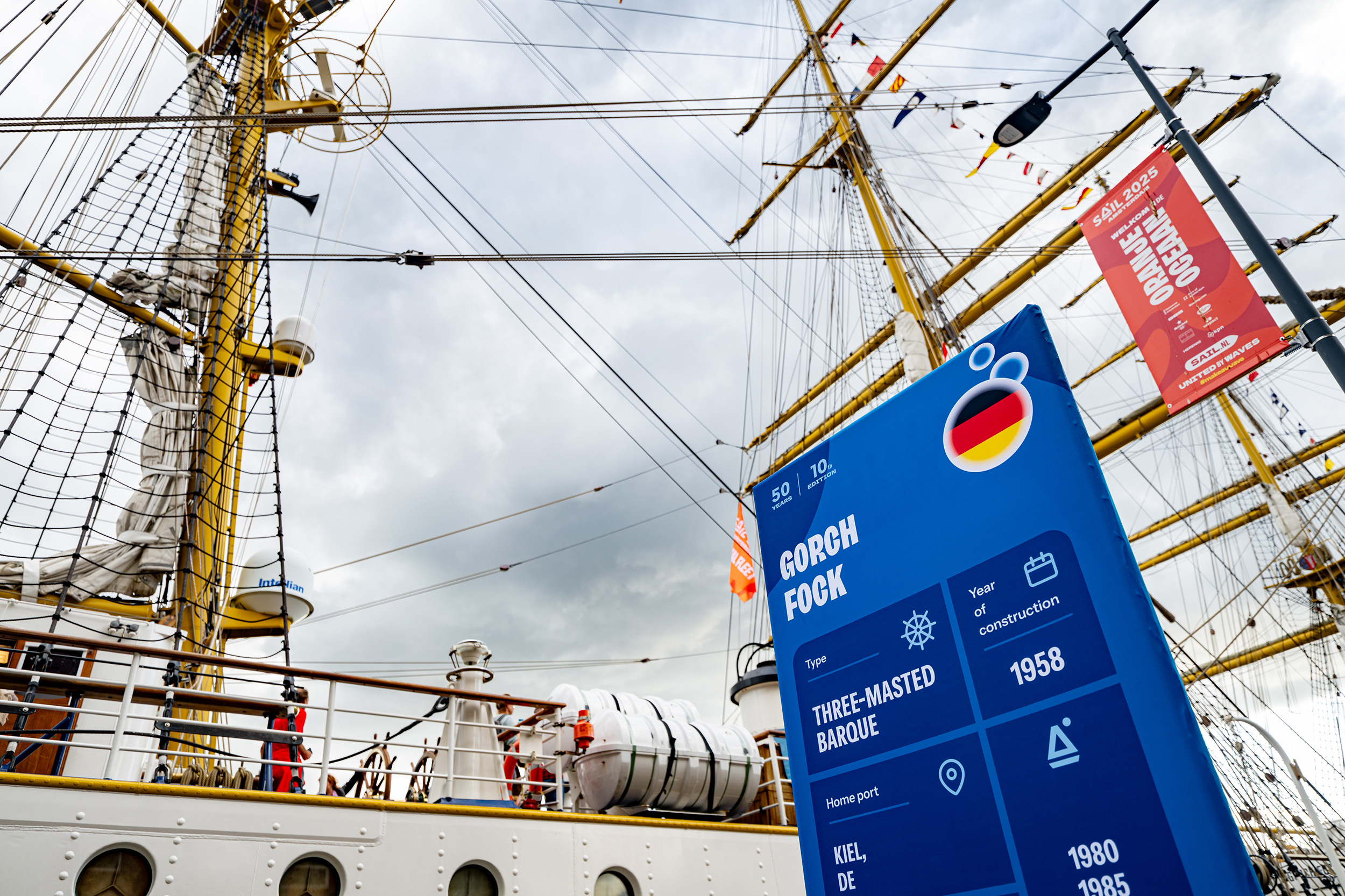 Een deel van taal ship Gorch Fock met daarbij een lollypop-infobord in de huisstijl van SAIL 2025.