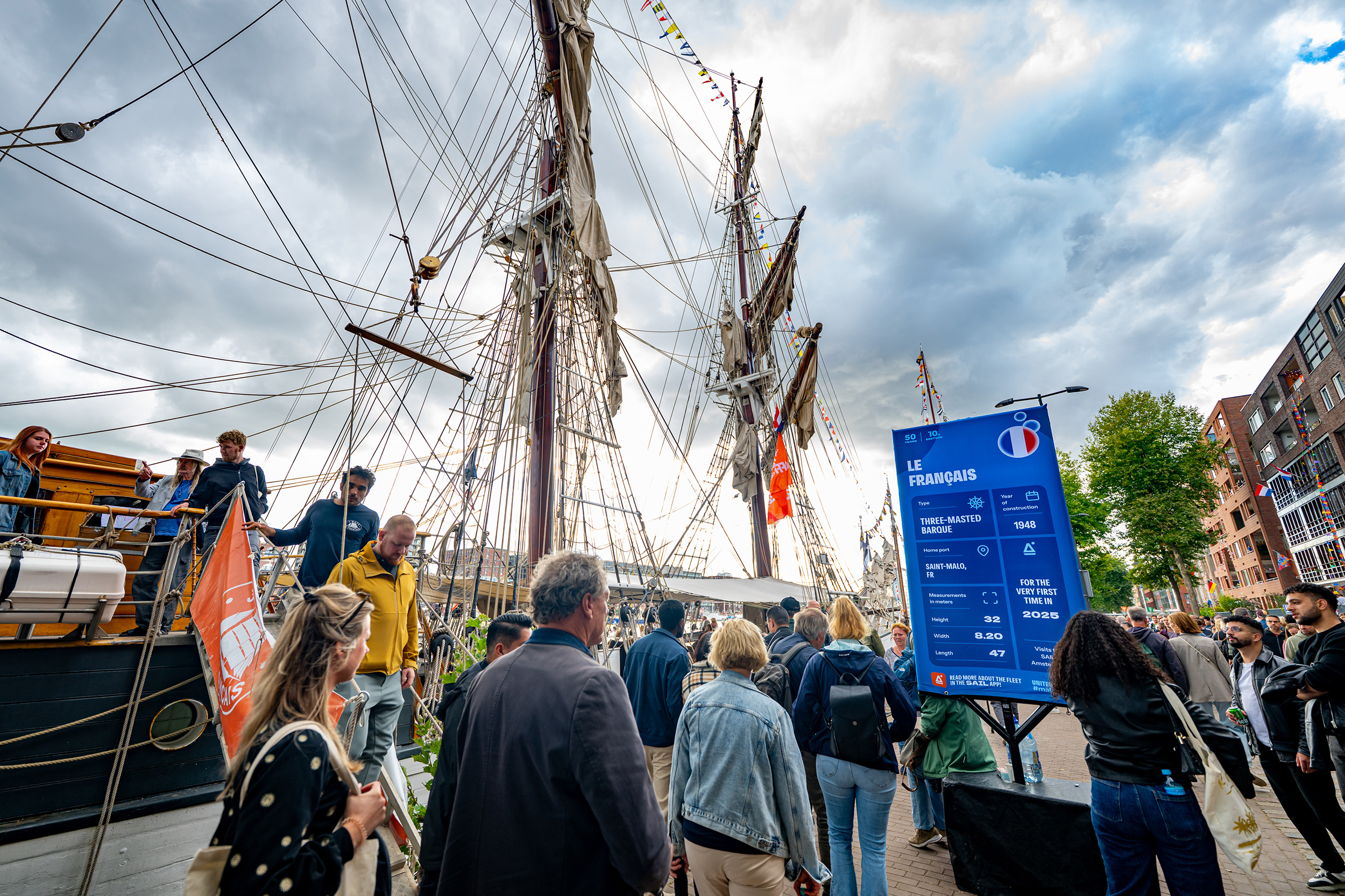 Tall ship Le Français met een lollypop-infobord in de huisstijl van SAIL 2025, en veel bezoekers.