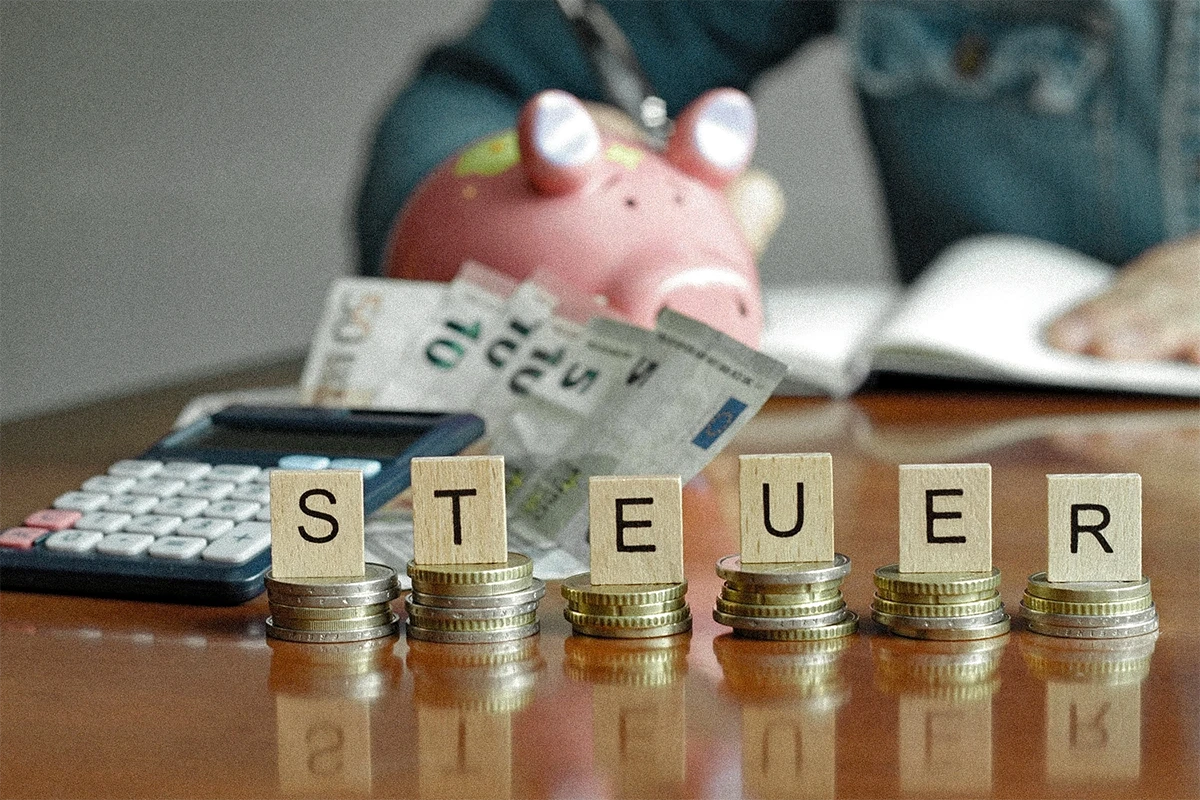 Steuern mit Sparschwein auf dem Schreibtisch