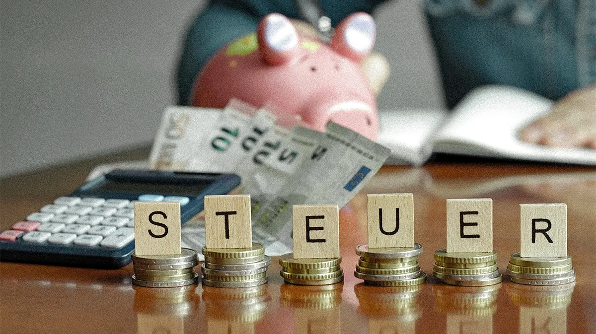 Steuern mit Sparschwein auf dem Schreibtisch