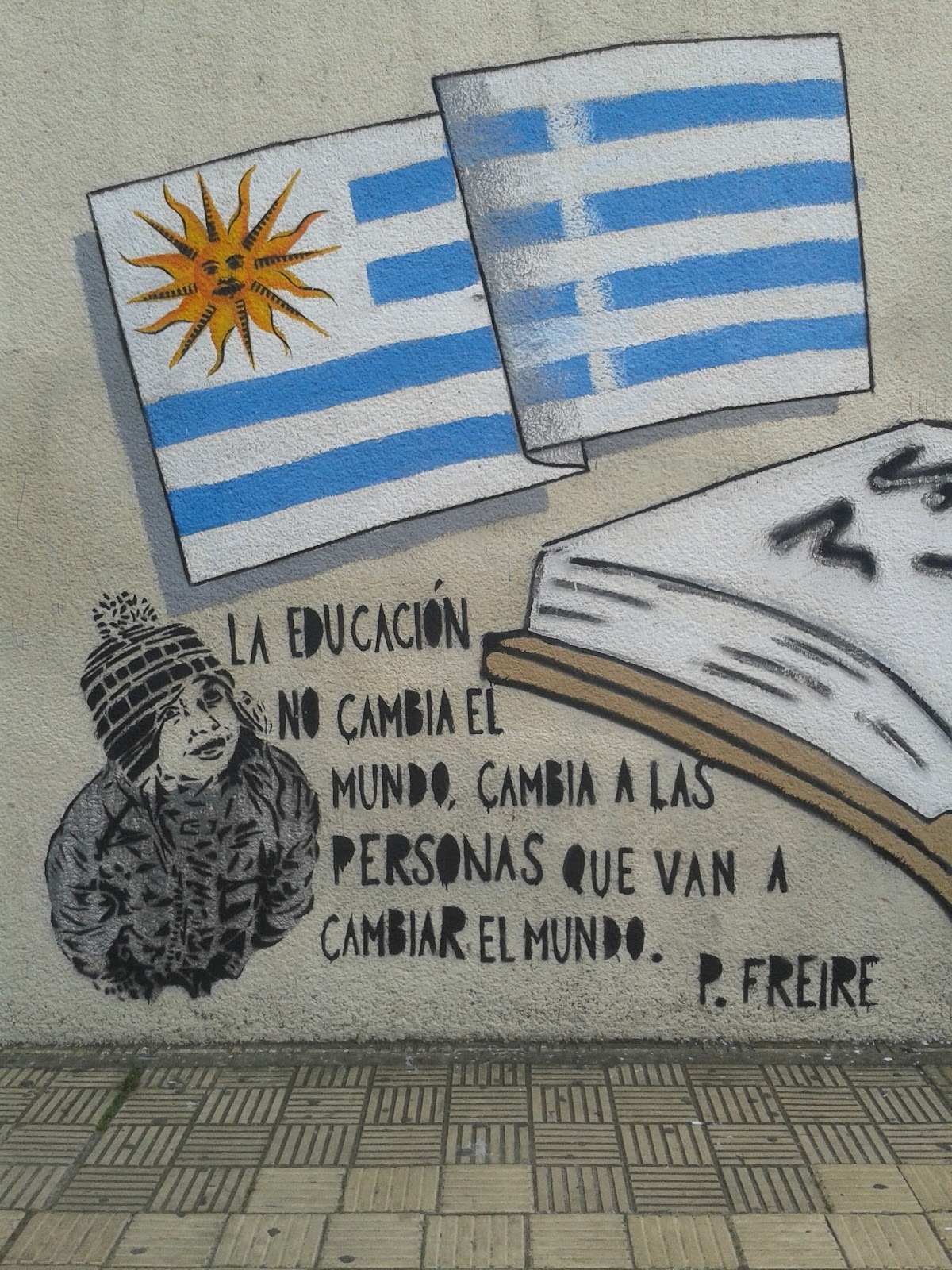 Graffitti on wall about education and uruguay flag