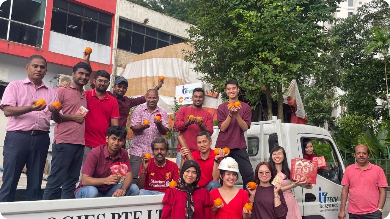 Team photo of diverse factory or logistics workers celebrating a milestone.