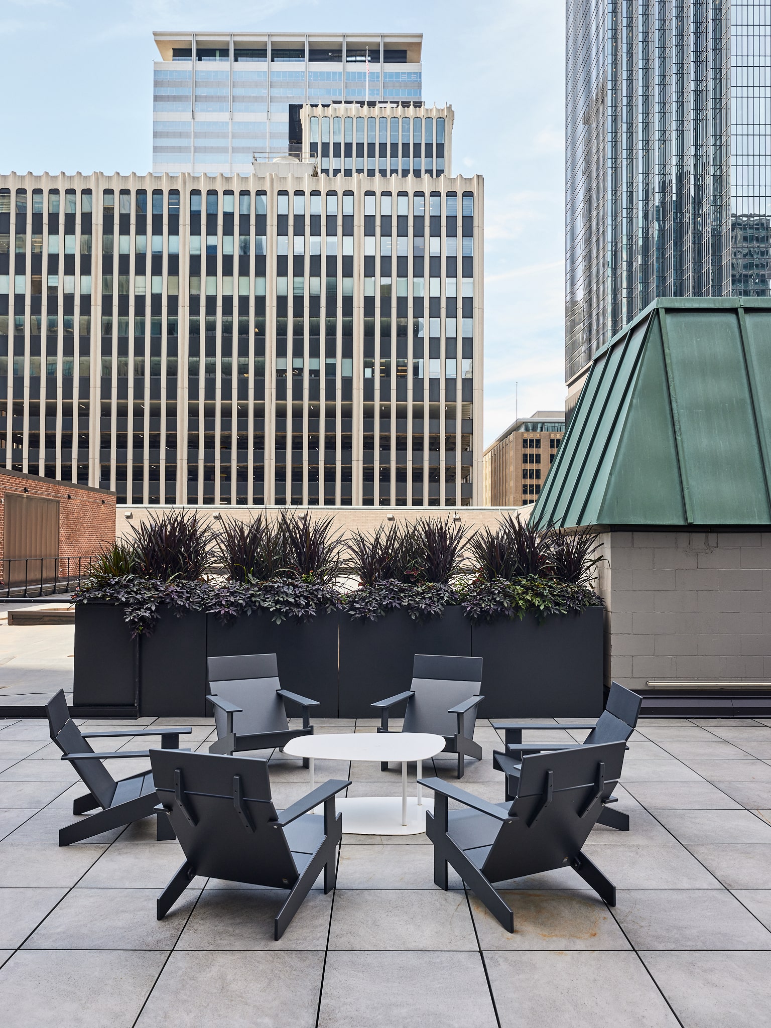 Rooftop seating area with modern planters and city skyline views