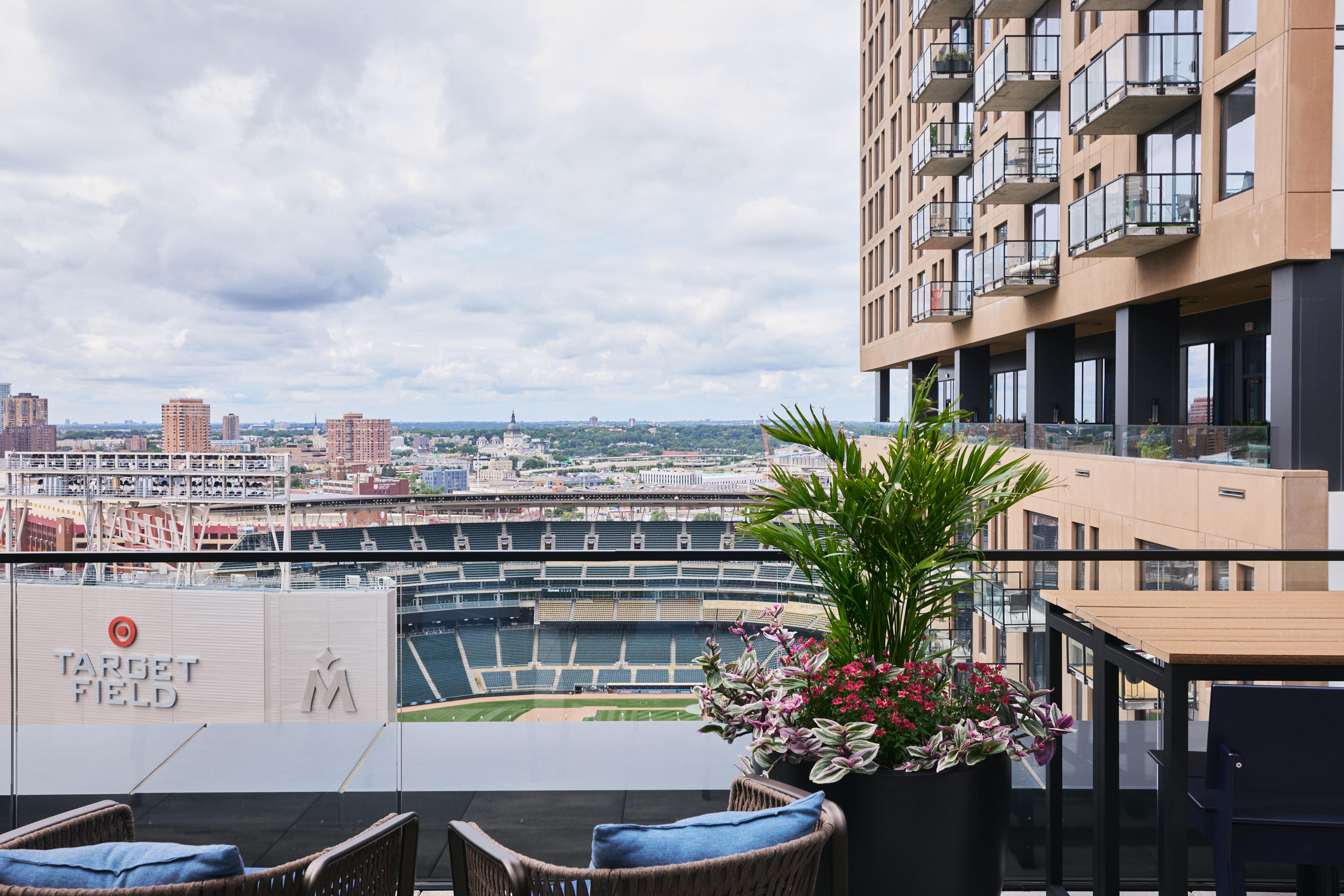 Rooftop balcony with lush planters overlooking Target Field and city skyline