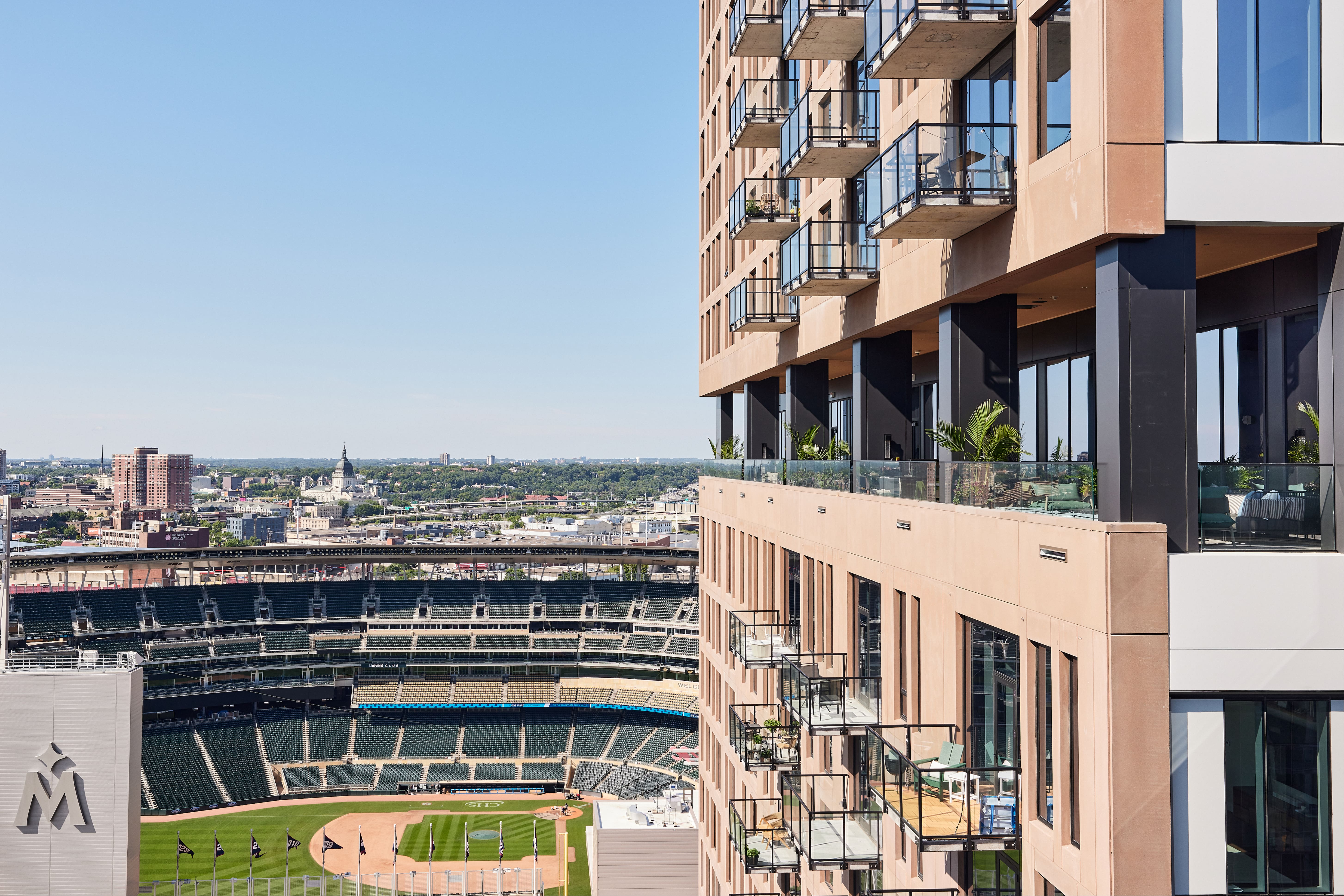 Apartment balconies and rooftop terrace overlooking Target Field and city skyline.