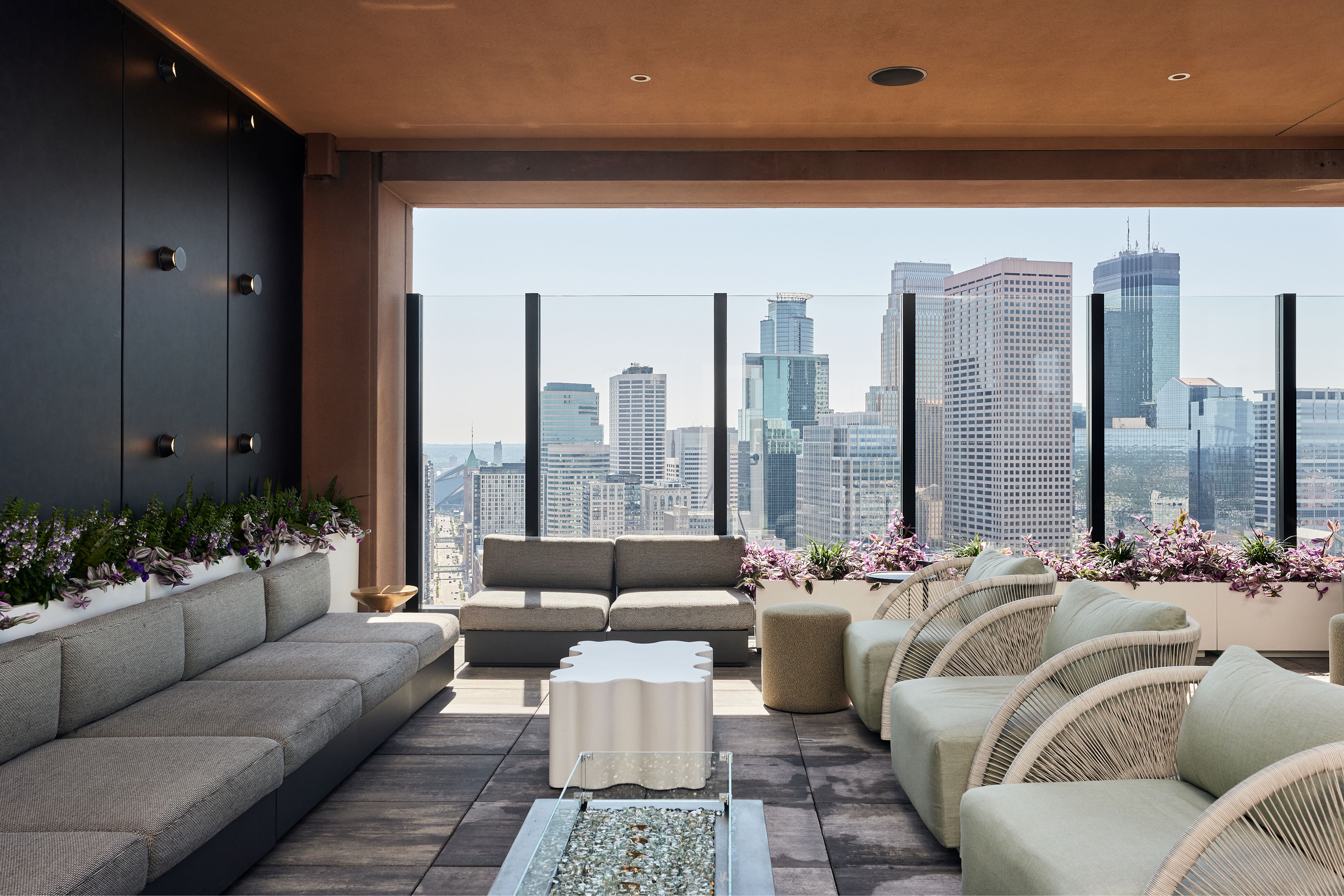 Modern rooftop lounge with skyline views and built-in planters