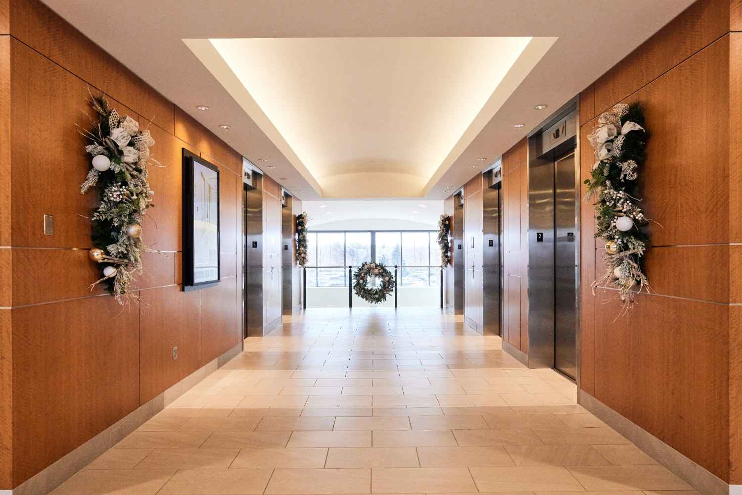 Elevator hallway decorated with holiday garlands and a Christmas wreath.