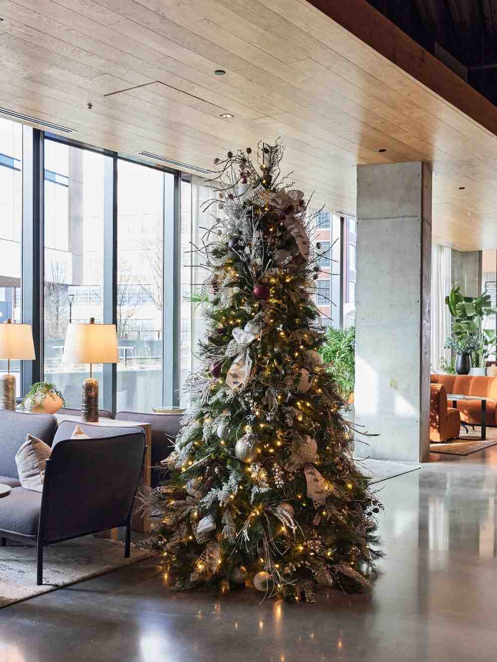 Decorated Christmas tree with warm lights in a modern lobby