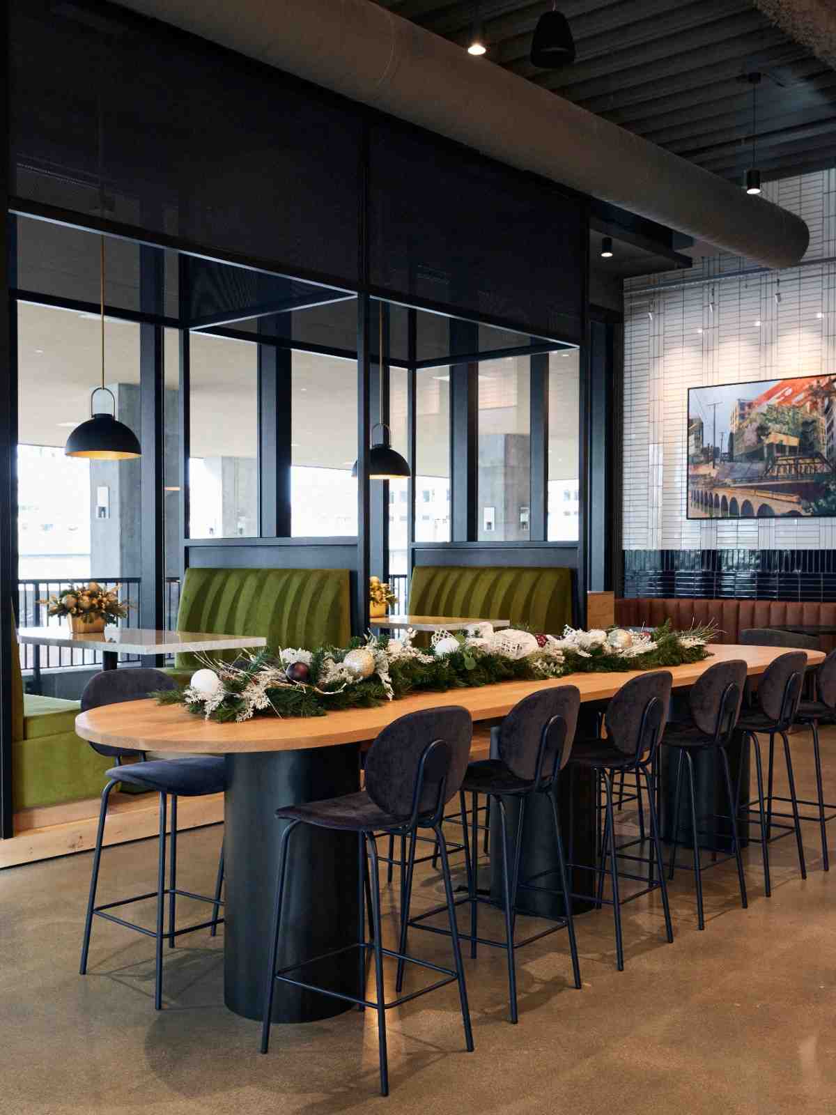 High-top dining table decorated with holiday garland in a modern lounge