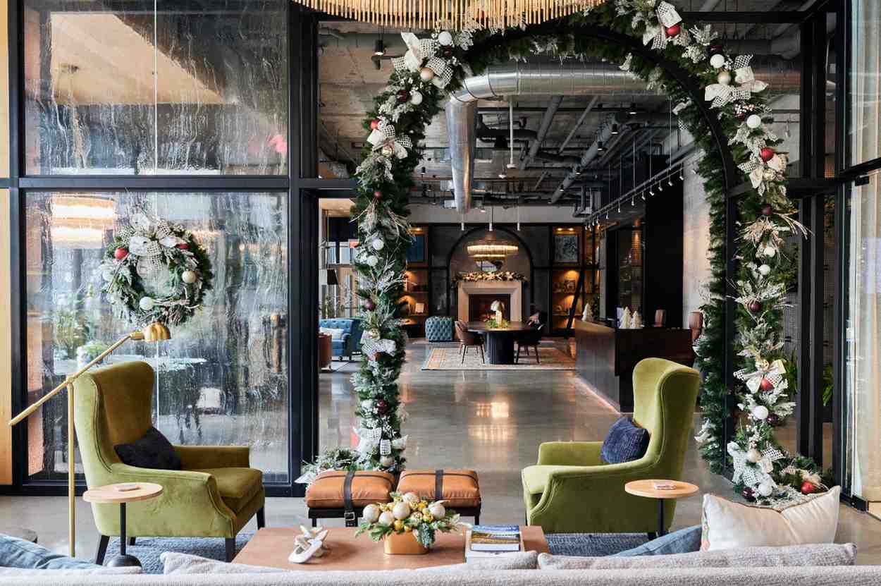 Lounge seating framed by a holiday garland arch with wreaths and festive décor.
