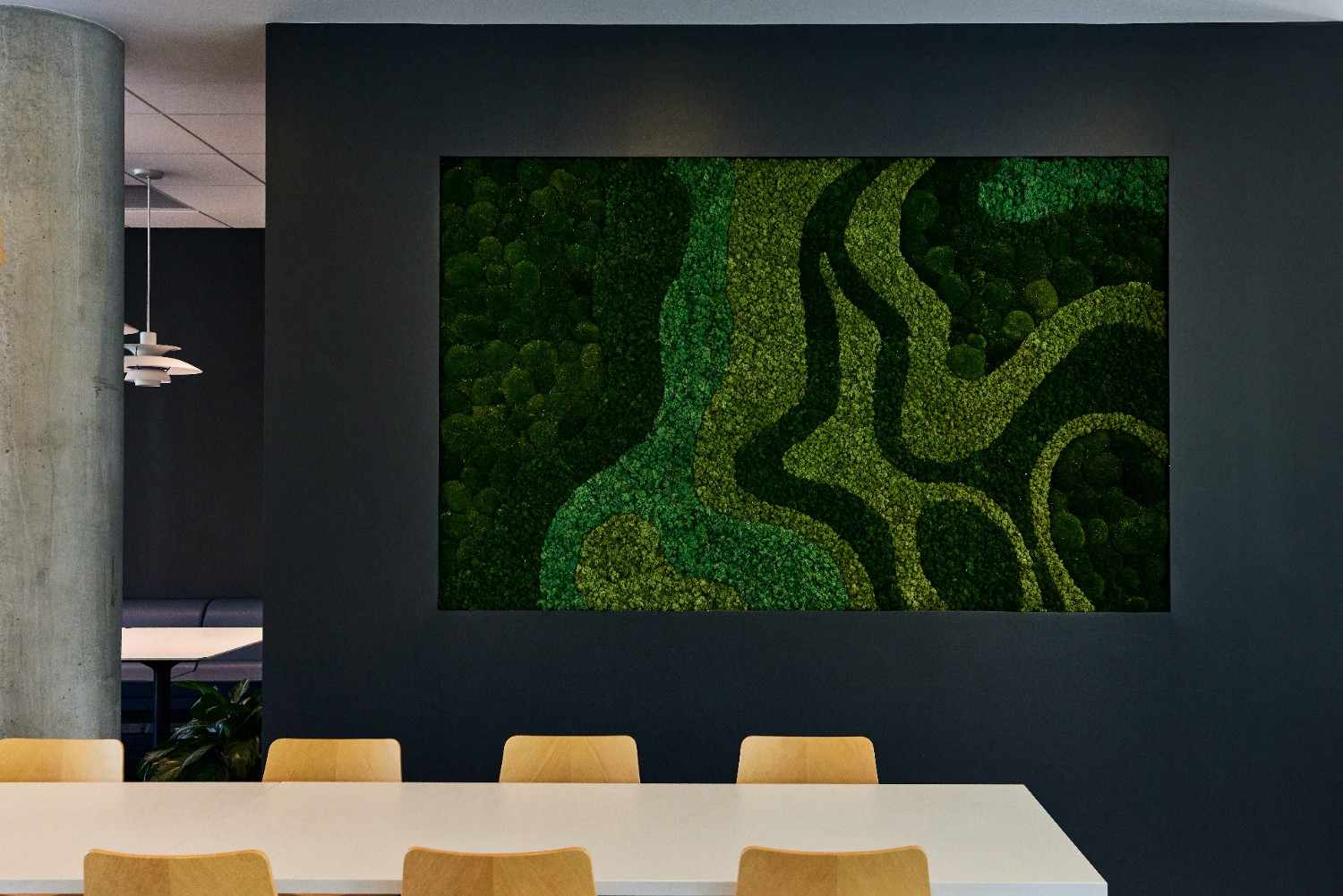 Framed moss wall art with layered green patterns displayed in a modern office meeting space
