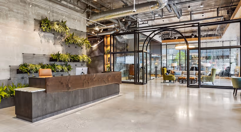 Modern industrial lobby with built-in green wall planters and contemporary seating area