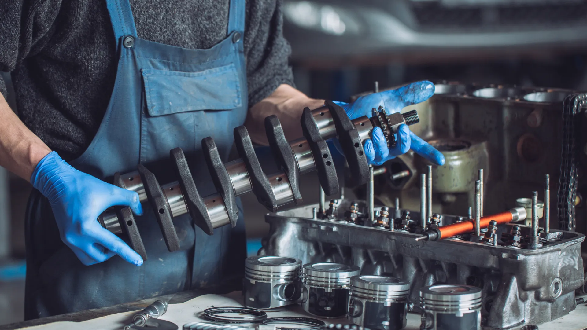A man in blue gloves working on a machine.