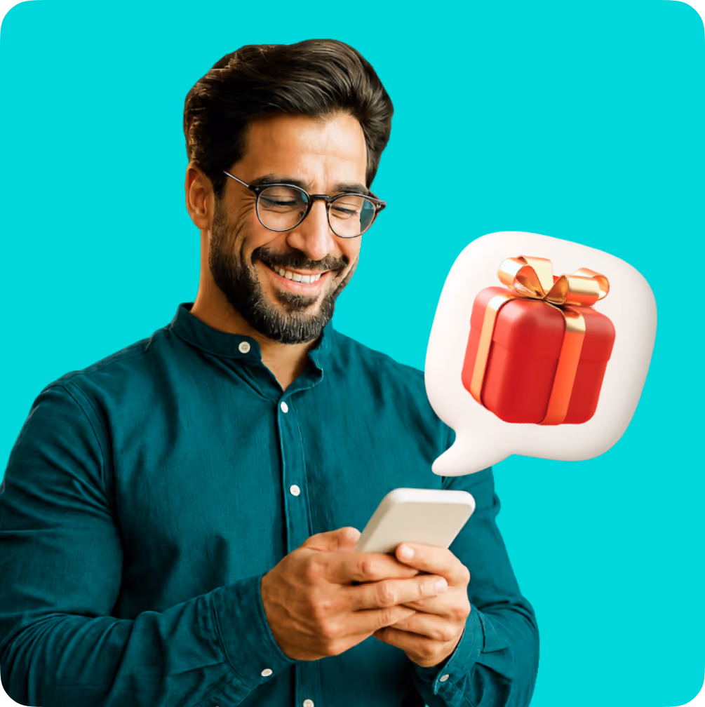 Smiling man in glasses holding phone with a speech bubble showing a gift box emoji.
