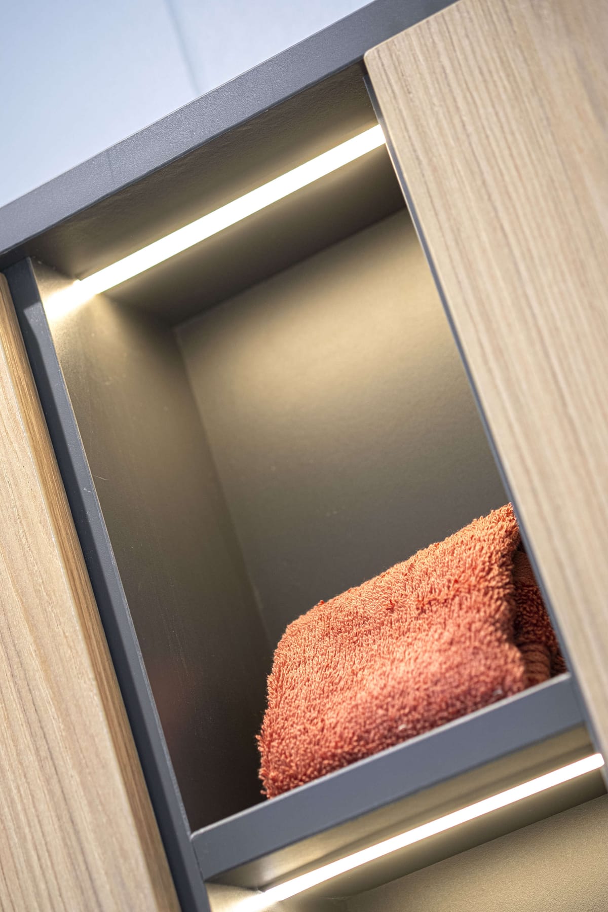 Illuminated Wooden Shelf with Folded Red Towel and LED Lighting