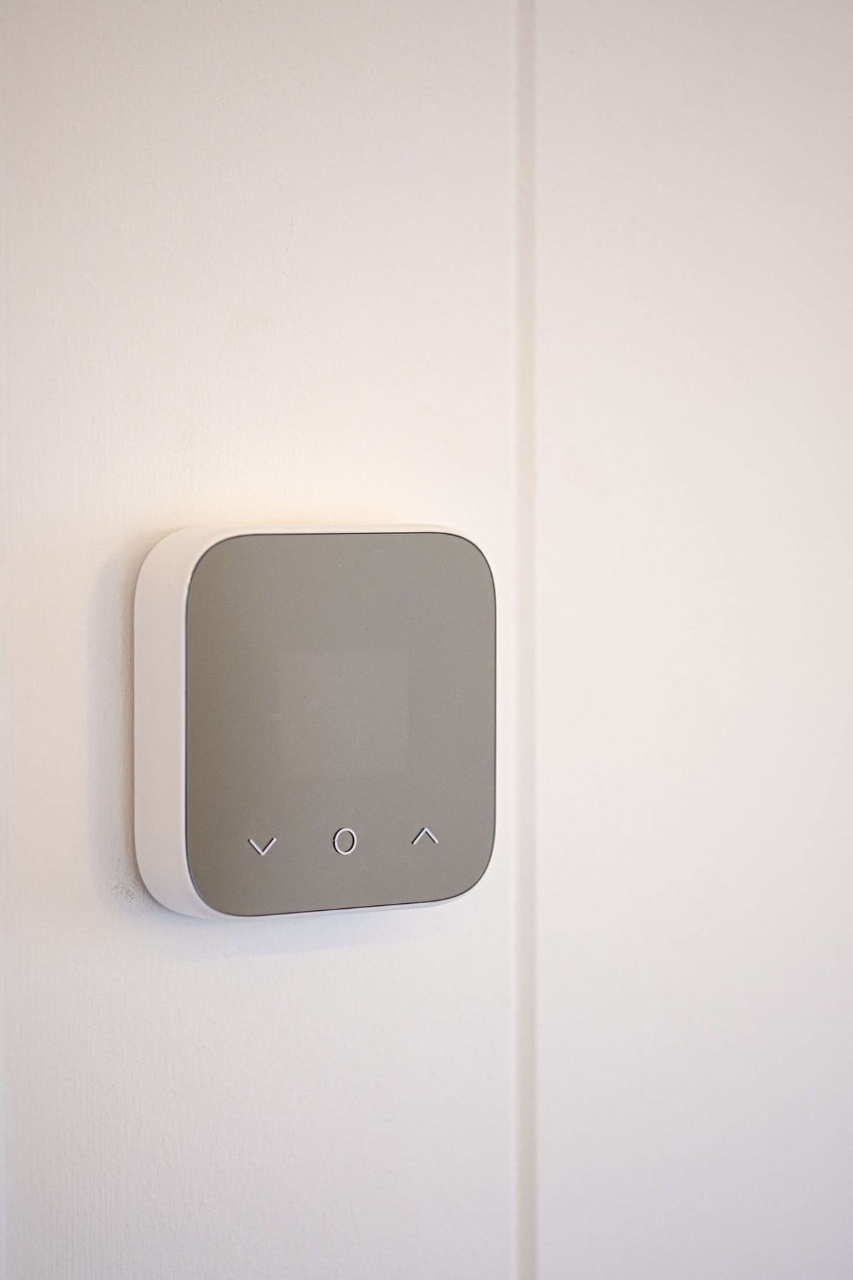 Minimalist Digital Thermostat Mounted on White Wall with Simple Control Buttons