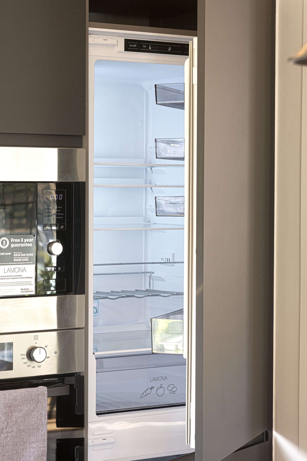 Modern Kitchen with Open Lamona Built-In Refrigerator and Stainless Steel Oven Displaying Empty Shelving and Storage Compartments