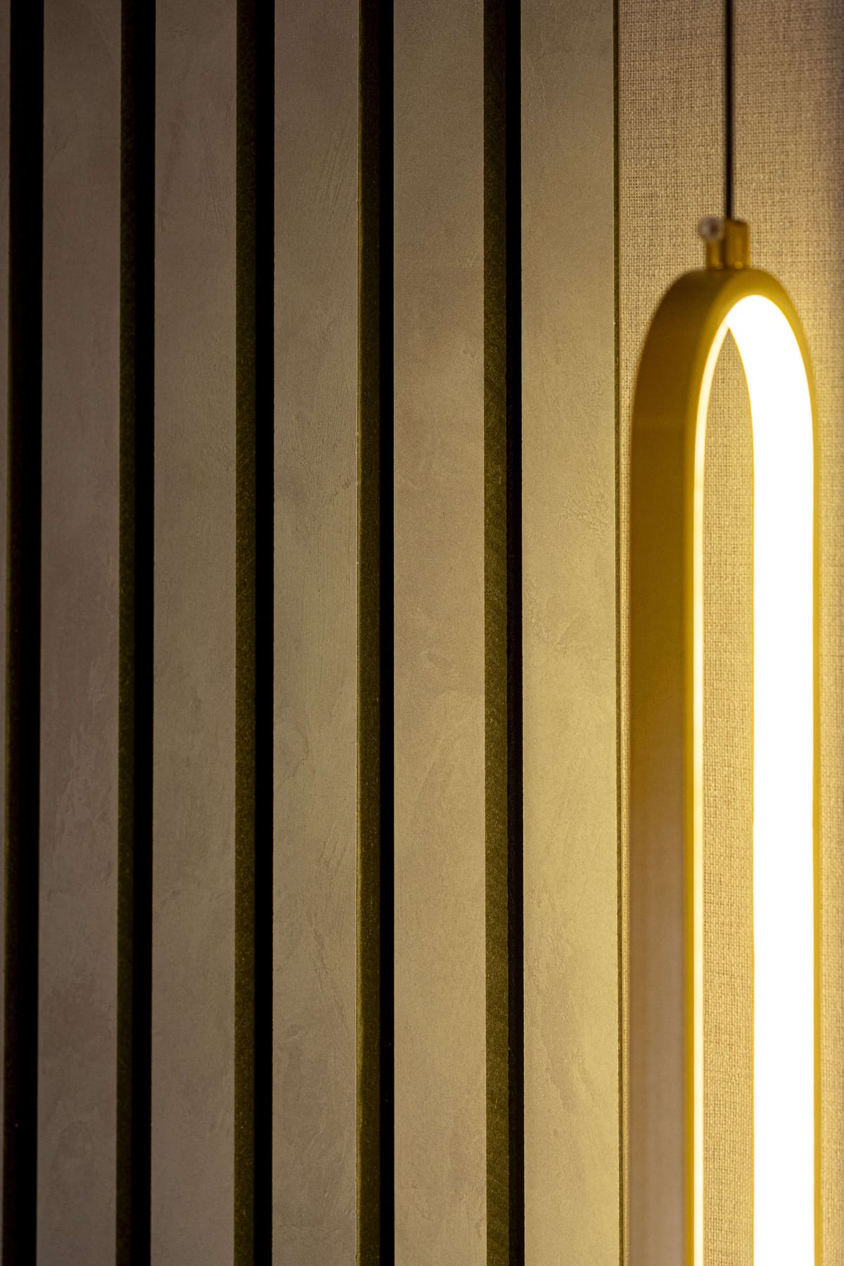 Warmly Lit Vertical Slats with Modern Minimalist Light Fixture in Soft Ambient Glow