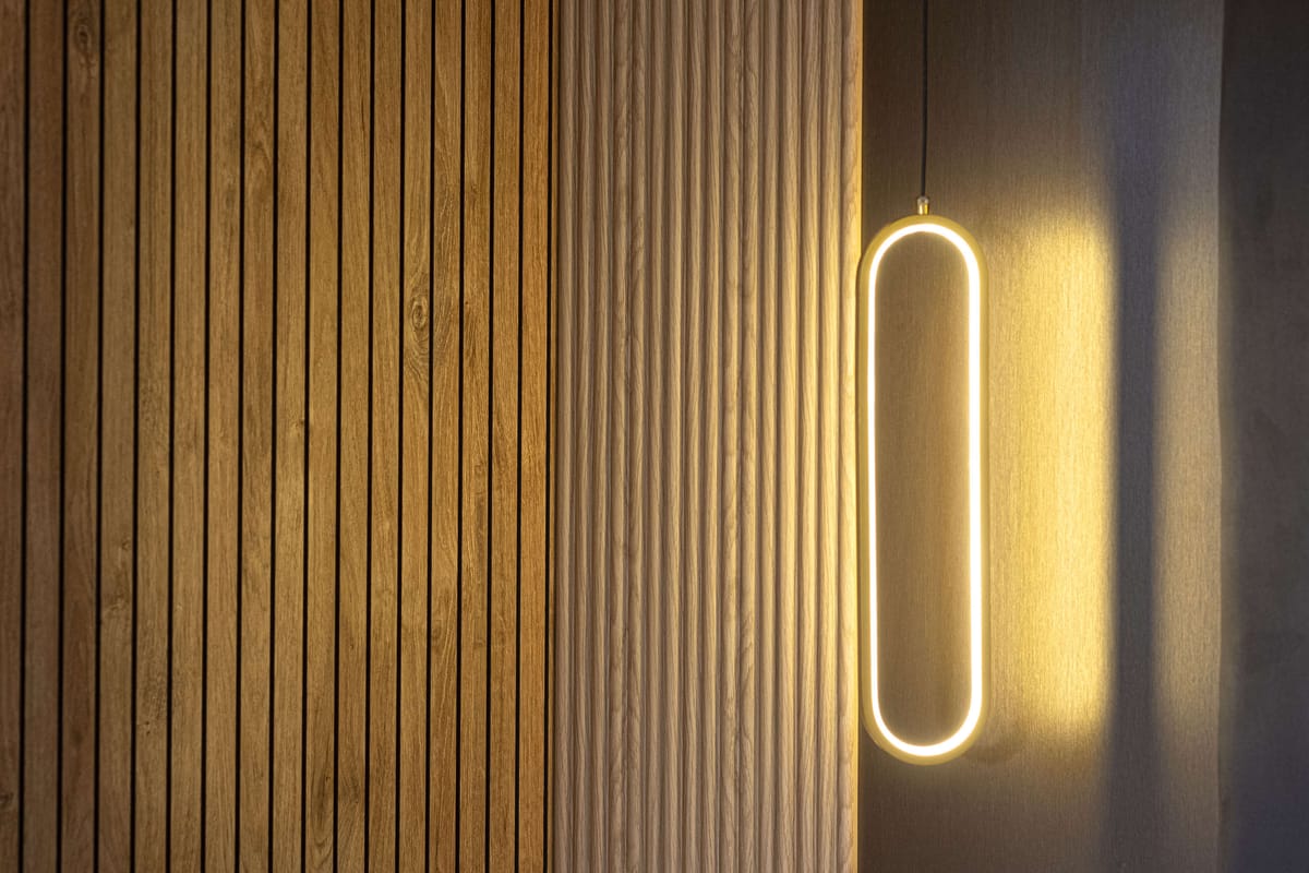 Modern Minimalist Interior with Vertical Wooden Panels and Sleek Oval Pendant Light Casting Warm Glow