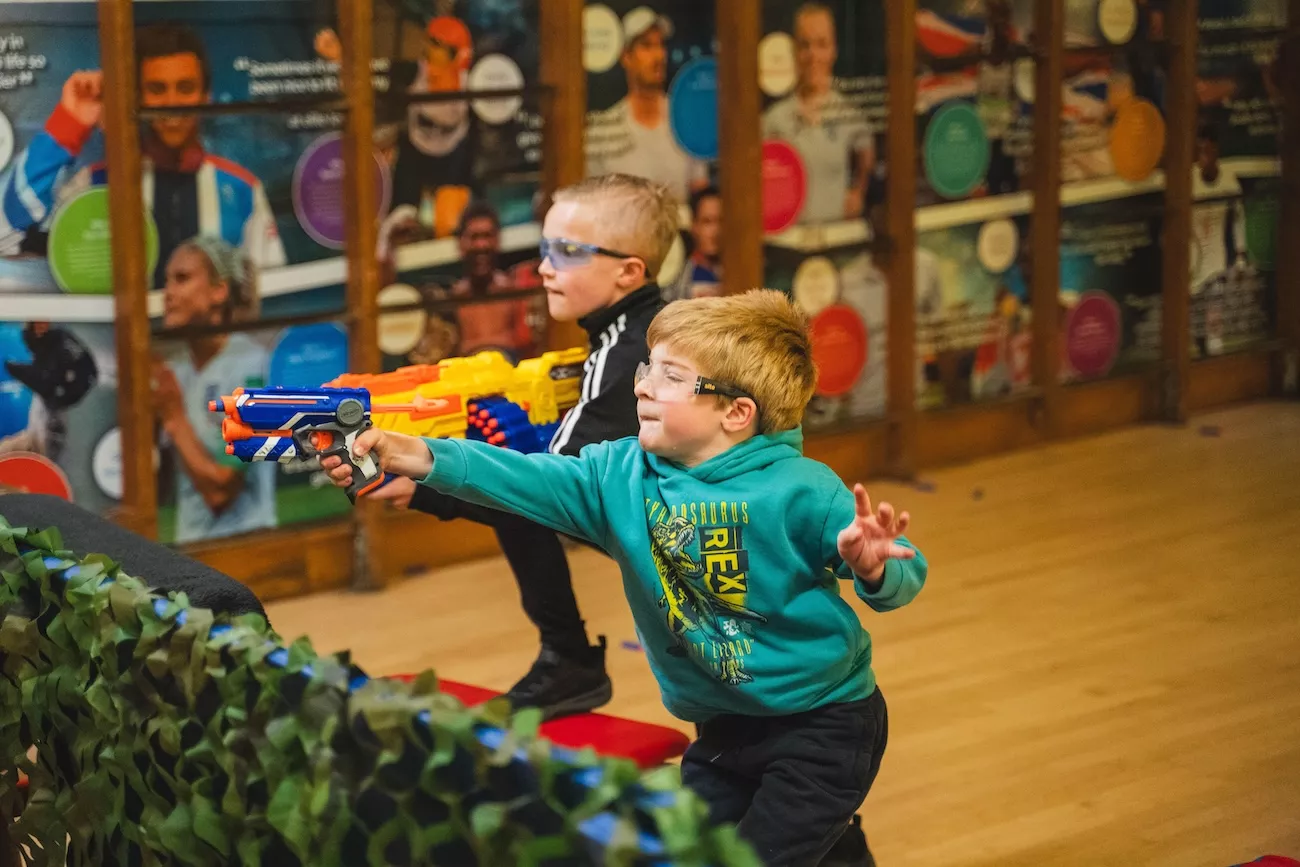 Two boys taking part in a Nerf birthday party in Worcestershire, armed with foam blasters and wearing safety glasses during a Delta Sports Coaching kid's birthday party.