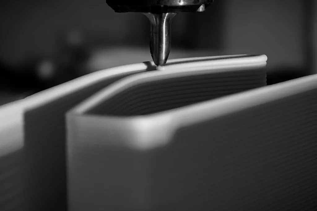 Impressora 3D depositando camadas de material para formar objeto em processo de fabricação.