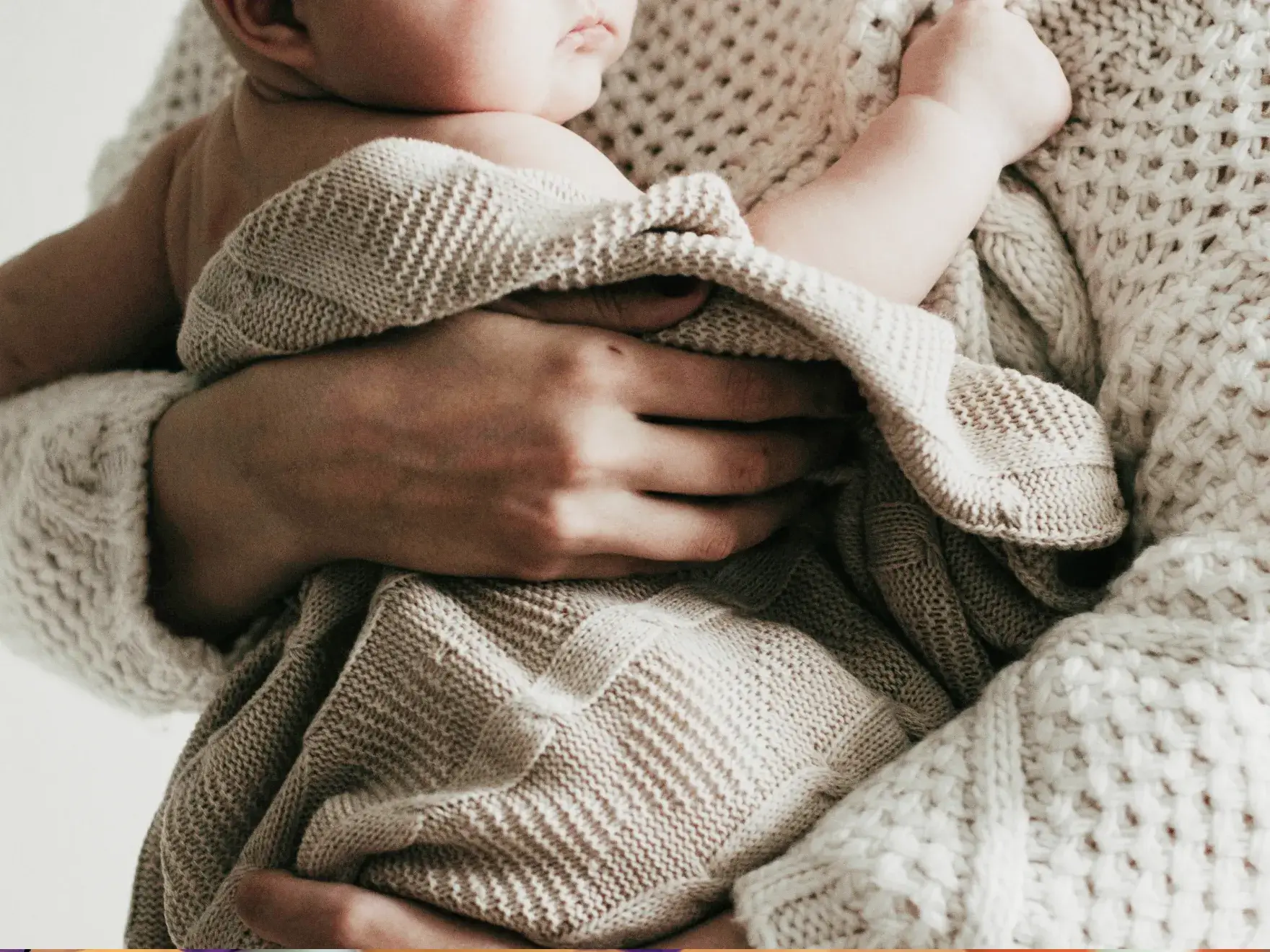 baby wrapped in a blanket being hold