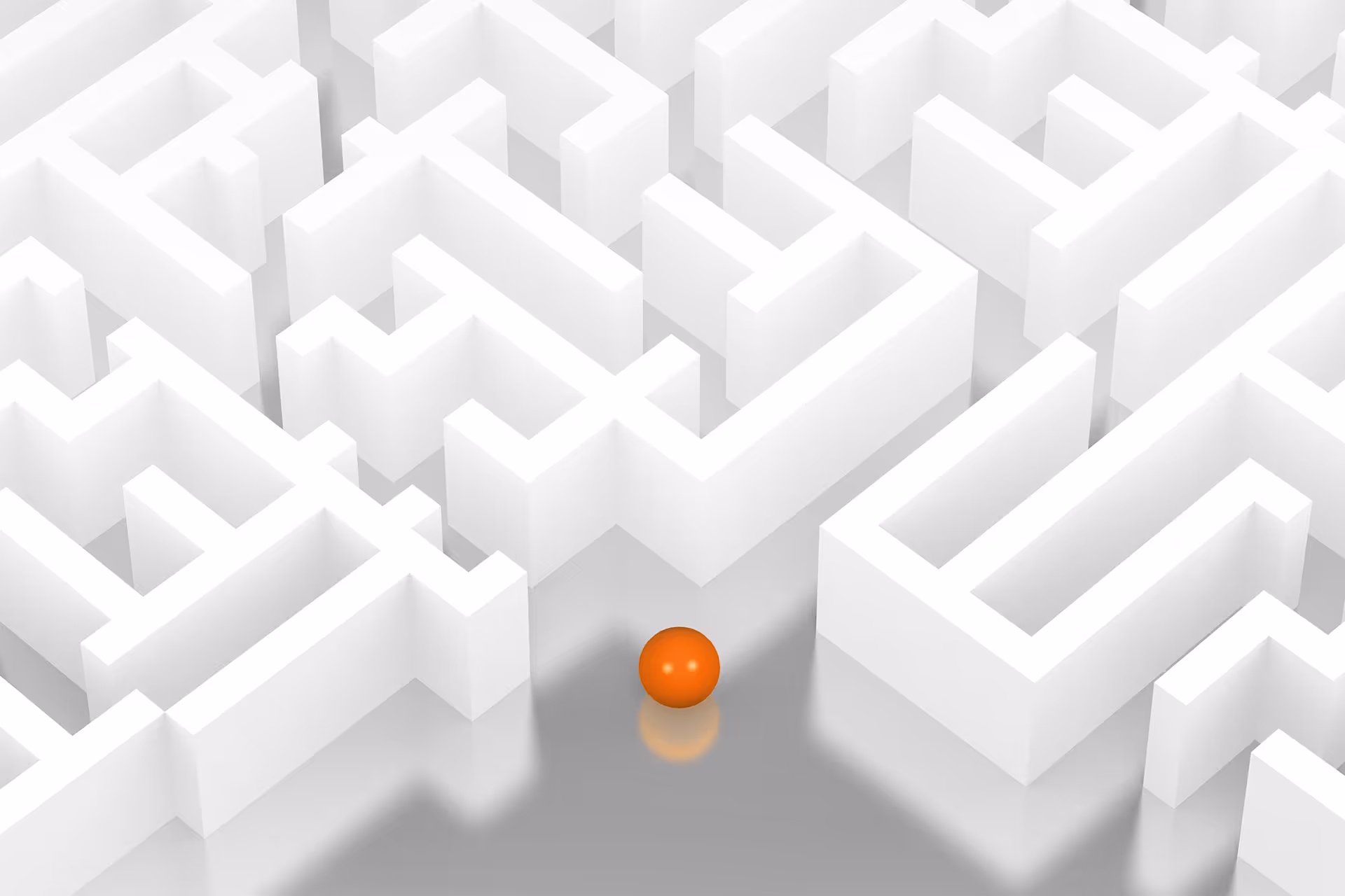 Ein weißes Labyrinth mit einer Orangenen Kugel vor dem Eingang