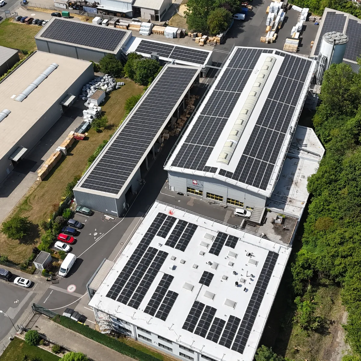 Vue aérienne de plusieurs toitures de halls équipées de modules photovoltaïques sur le site d'Eschweiler
