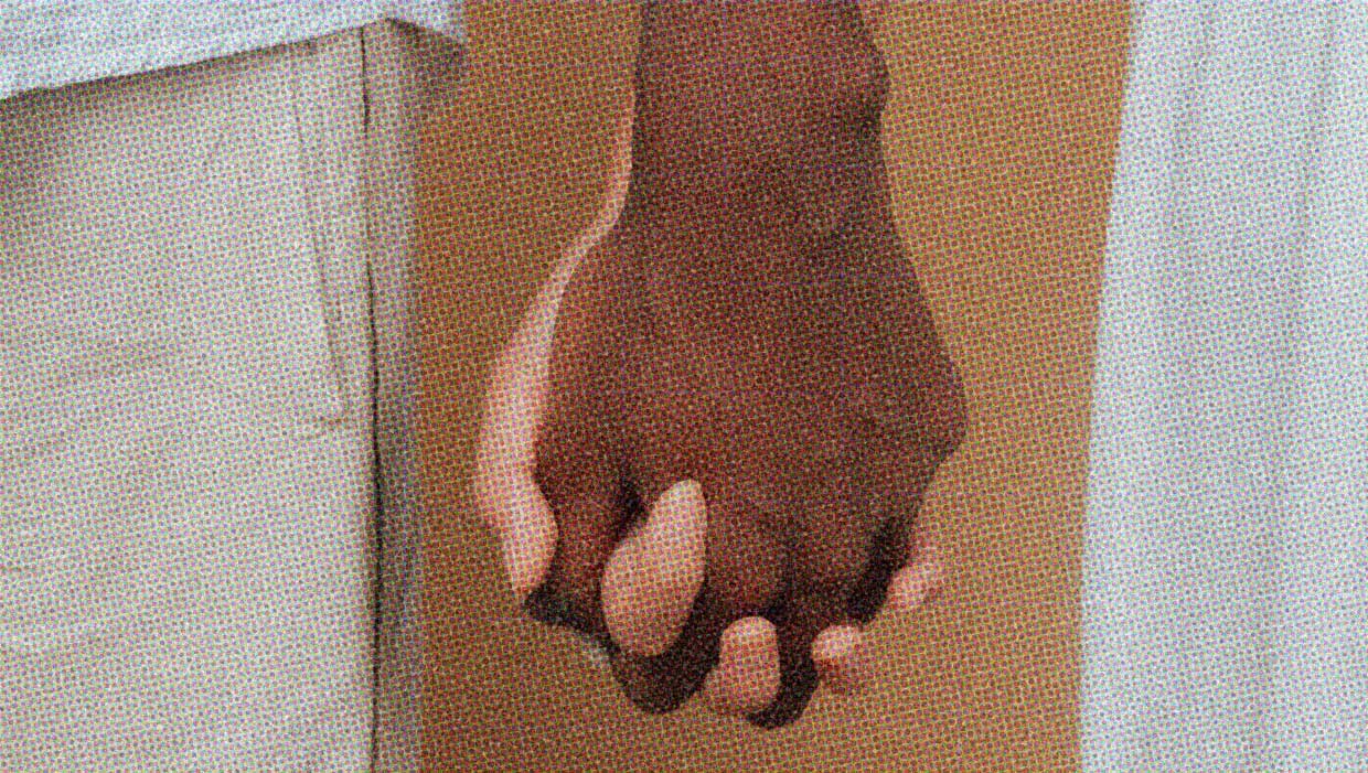 A close-up of two people holding hands.