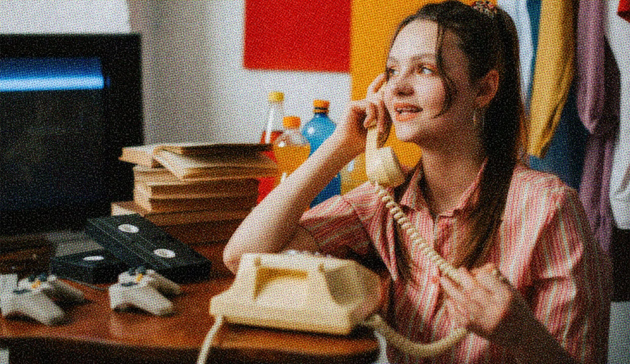A woman chatting on an early 2000's landline phone.