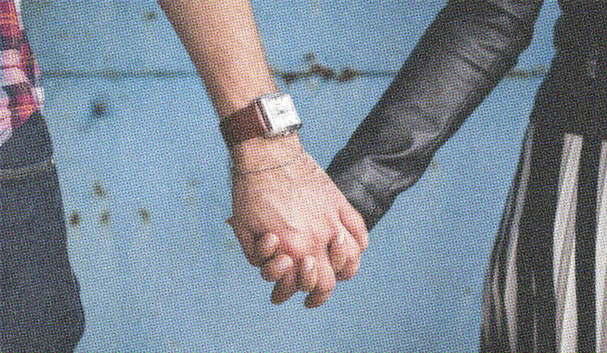 Close up image of a couple holding hands.