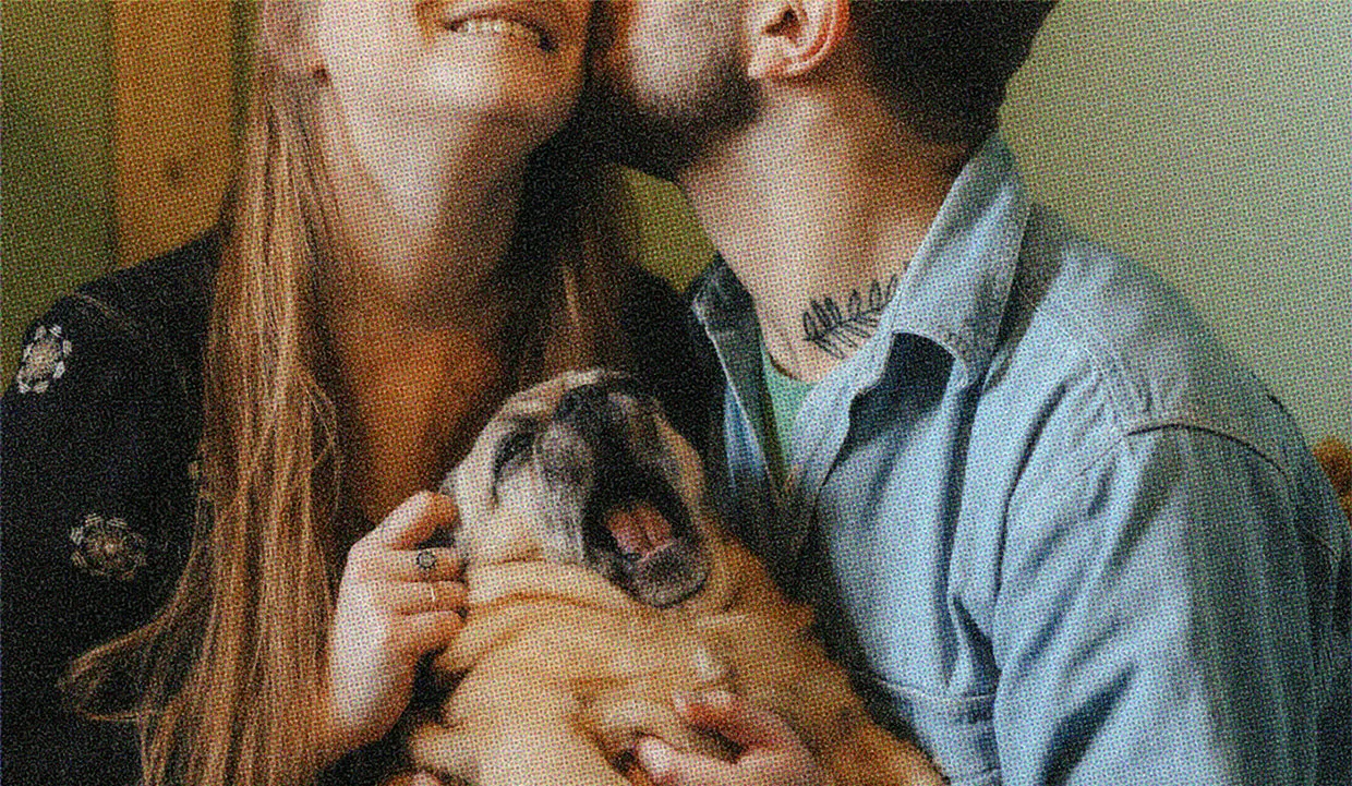 A family photo of a couple and their fur baby.