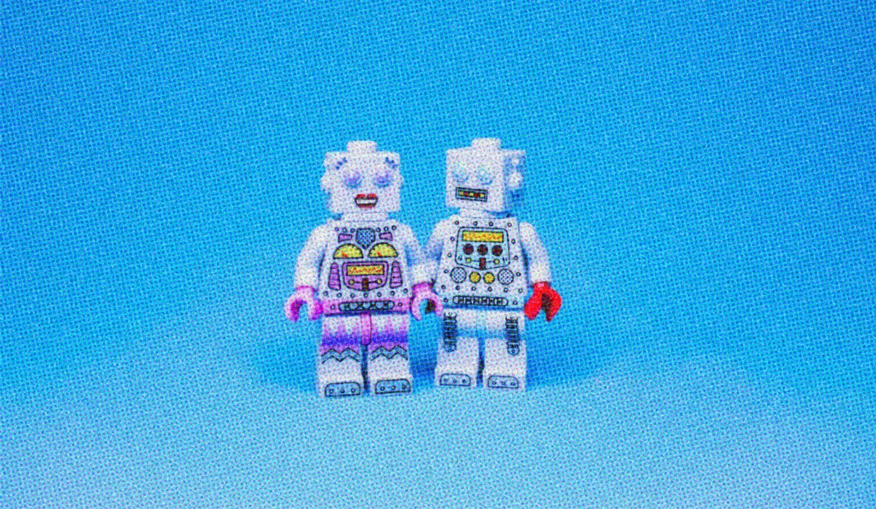 A couple of lego figurines on a pale blue background.
