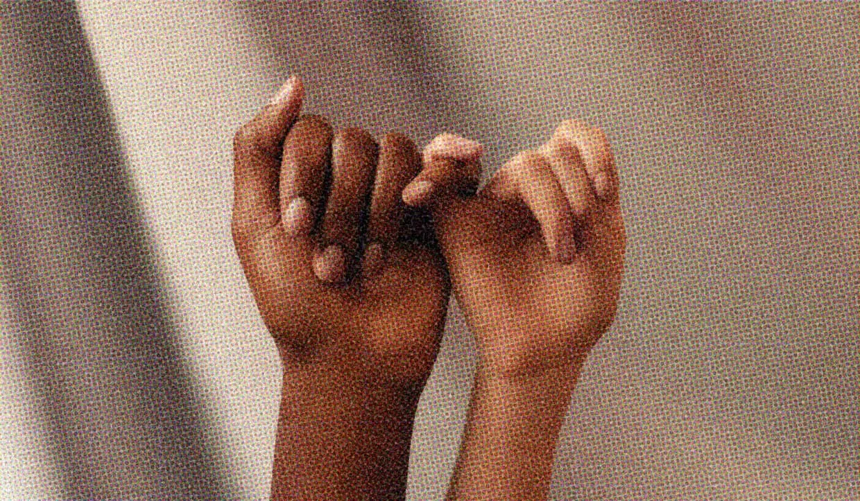 Two hands, with pinkie fingers intertwined.