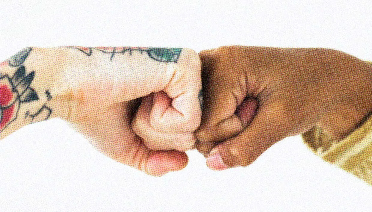 A close-up of two people fist-bumping.