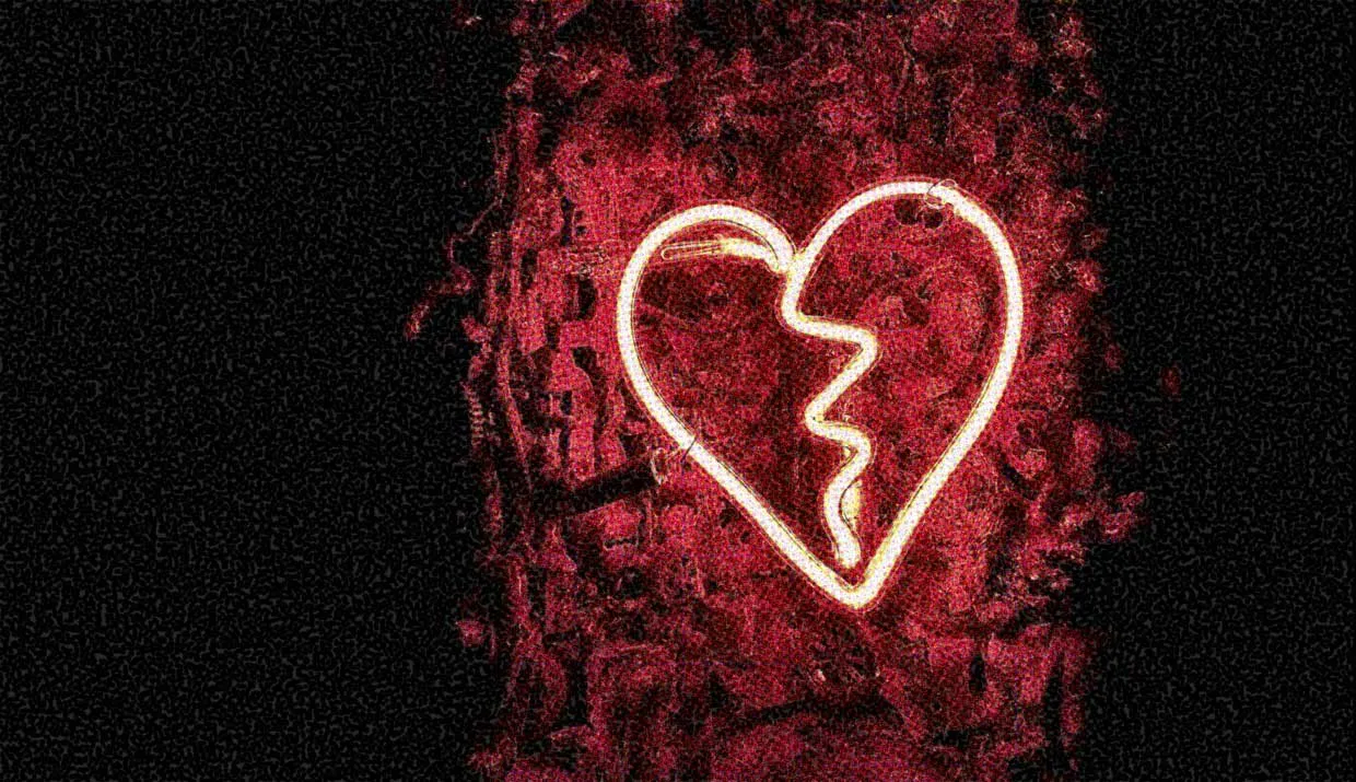 A red neon sign shaped like a broken heart.
