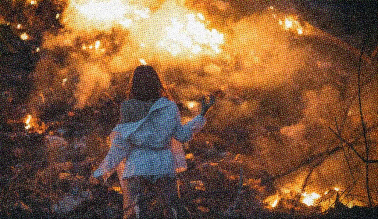 HUD App - Woman standing in front of bonfire - Having fun when the world is falling apart