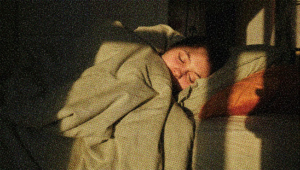 A woman is hibernating in bed, with covers pulled up around her face.