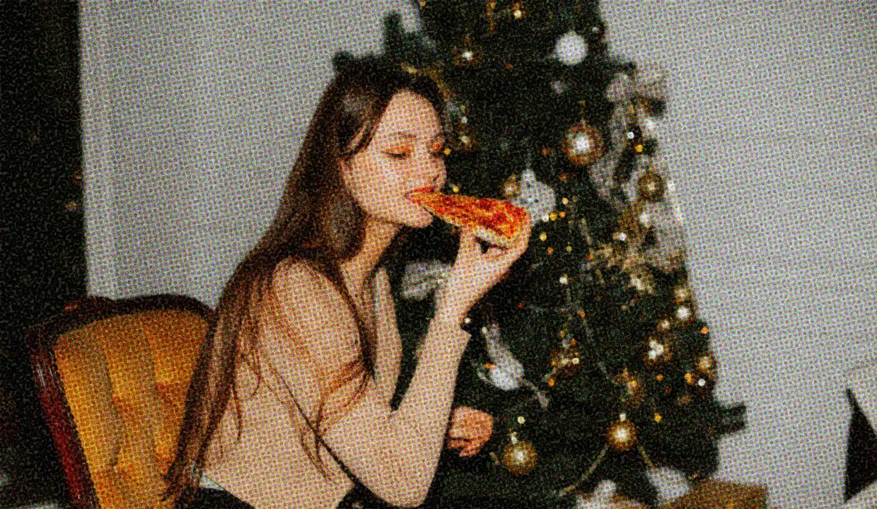 HUD App - Woman eating pizza in front of Christmas tree - Lonely at Christmas