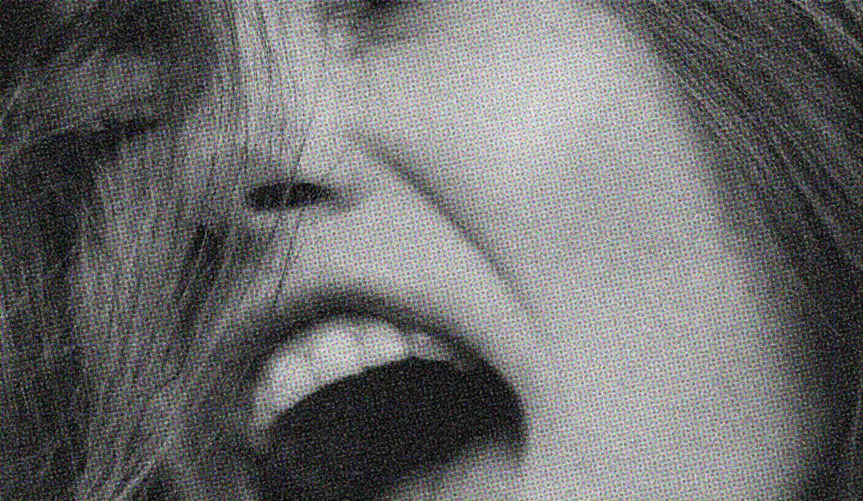 A black-and-white close-up of a woman's face. Her mouth is open and her eyes are closed, and she looks like she's either shouting, or laughing, or maybe she's in the throes of a climax... Or maybe she's just a really good actress.