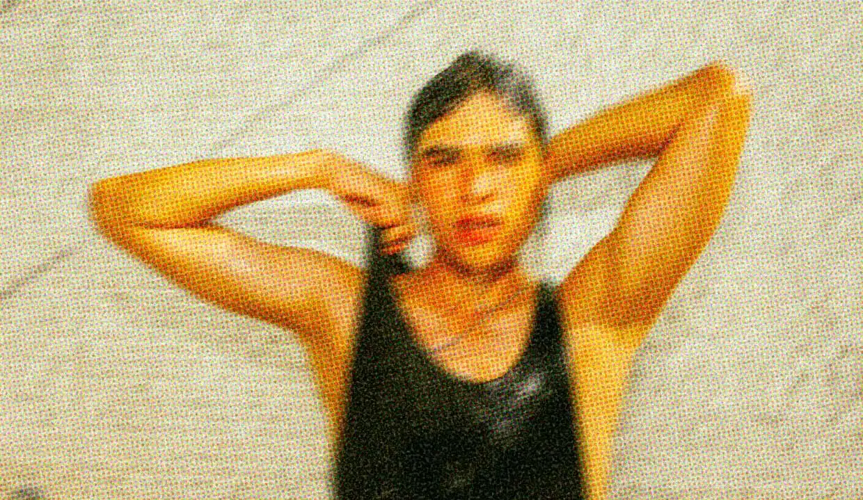 A person wearing a black singlet is drenched in water.