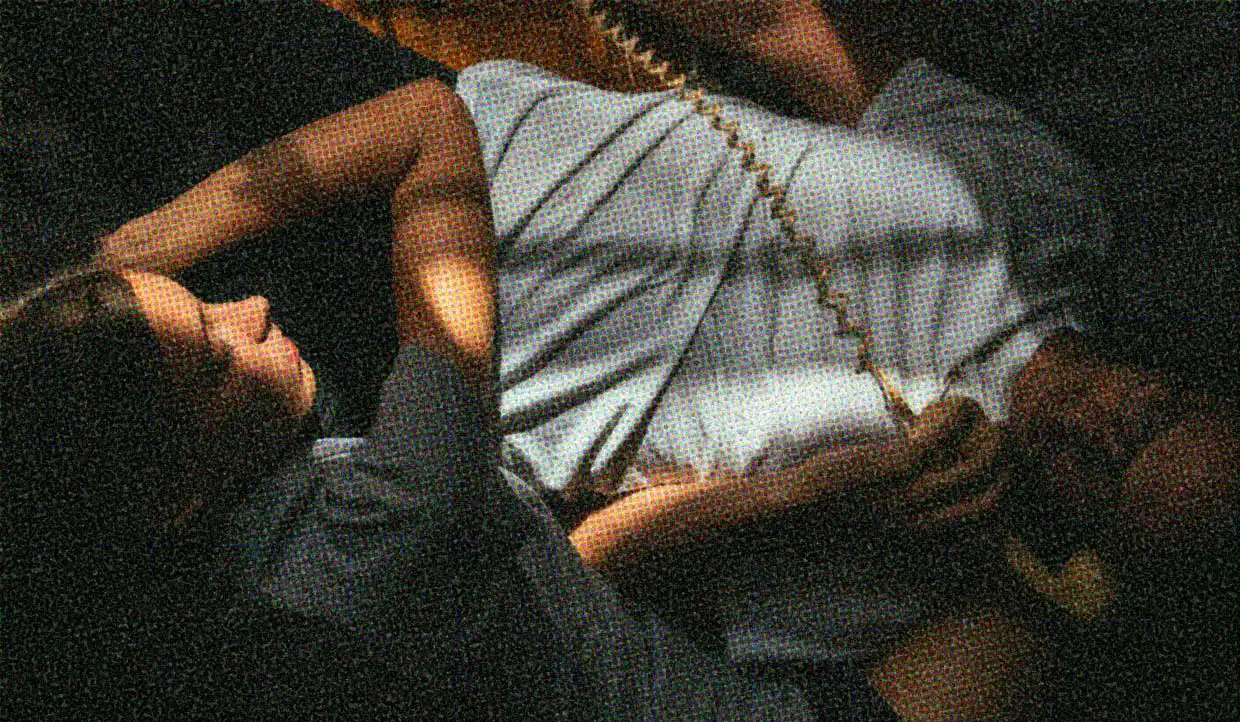 A couple cuddle on the floor. He is using an old-fashioned spiral-corded phone, while she lays across him.