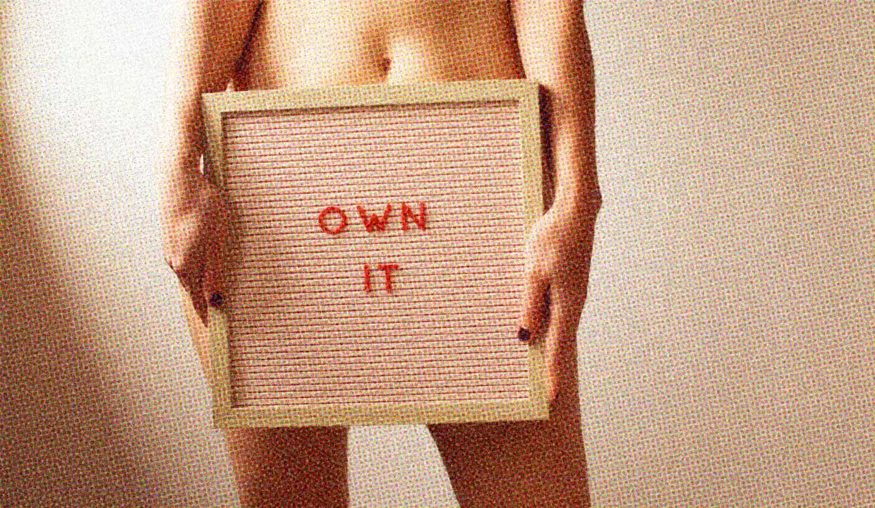 A woman holds a signboad that reads "Own it". She is unclothed.