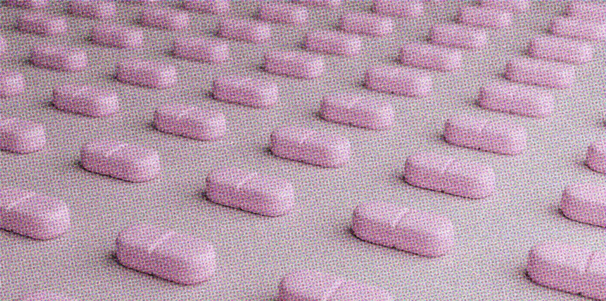 Pink pills are lined up in rows.