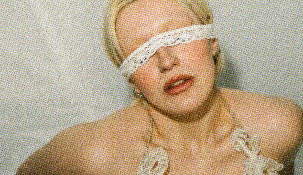A close-up of a woman wearing a piece of lace over her eyes, so she cannot see.