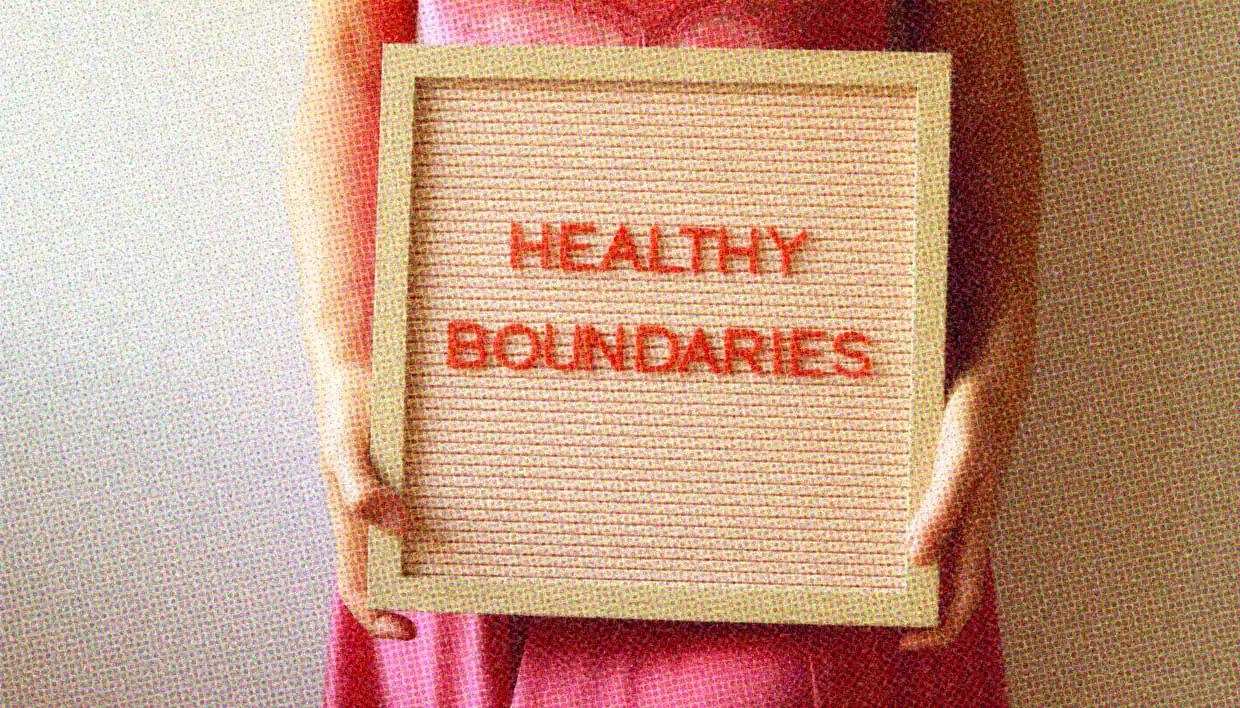 A close-up of a woman holding a signboard that reads "healthy boundaries".