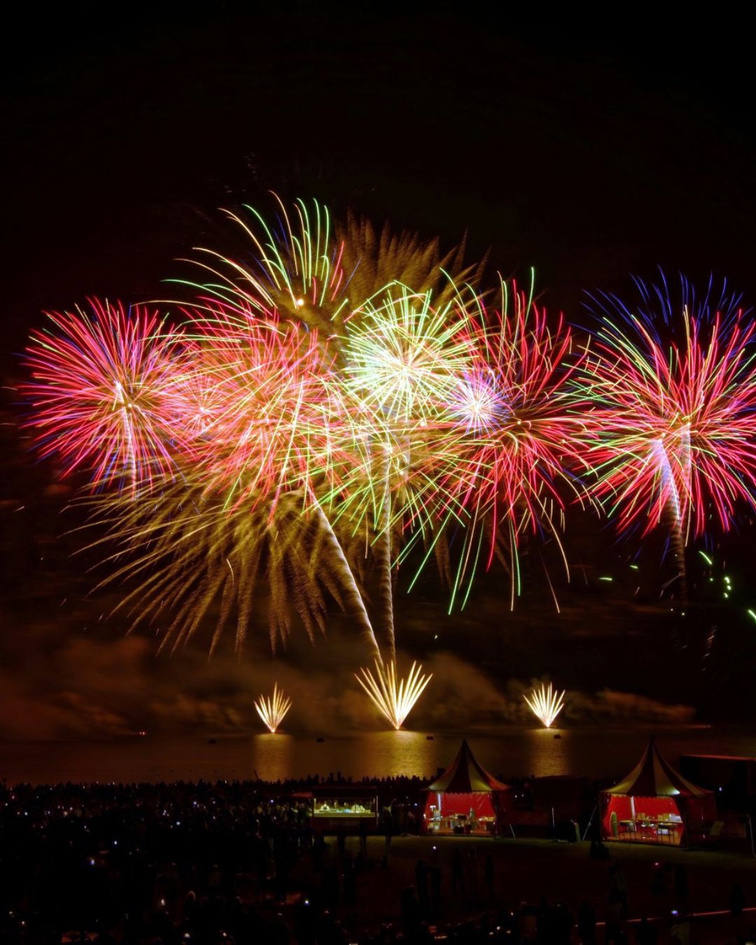 Spectacle pyrotechnique multicolore avec fontaines dorées au bord du lac de Madine, grande foule réunie pour un feu d'artifice professionnel réalisé par Wagnon Group.