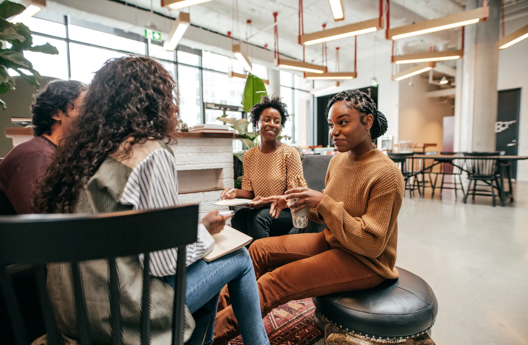 A group of women sitting around a table talking.